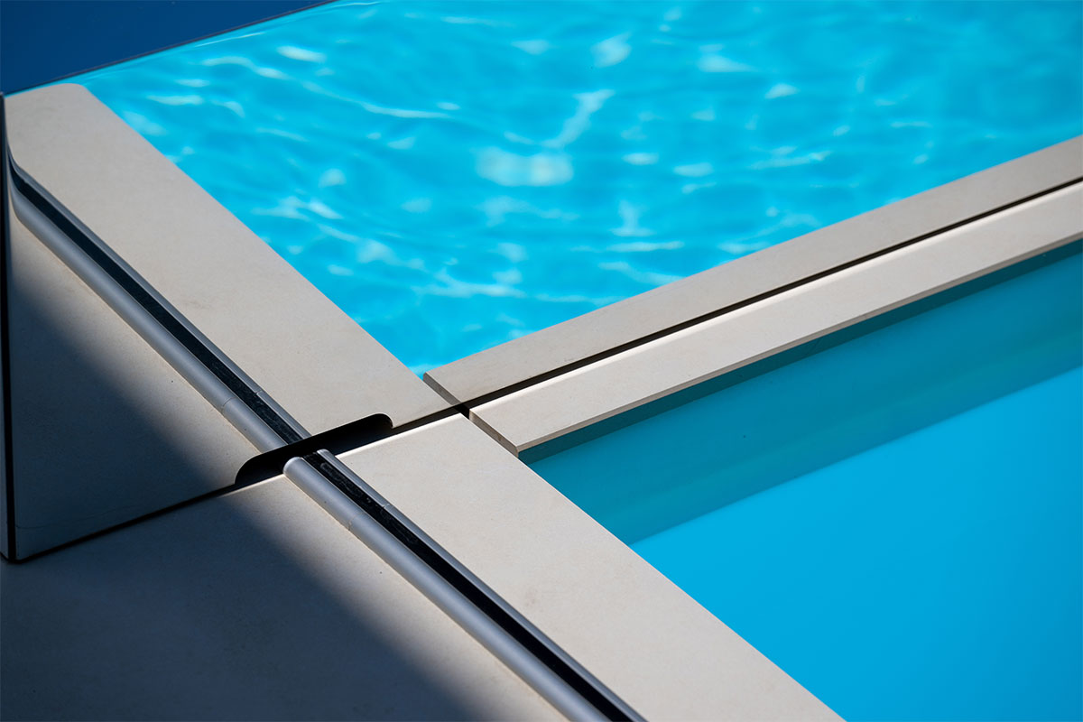 Gros plan sur les rails discrets de la couverture Coverseal intégrés dans le carrelage de la terrasse, assurant une finition élégante.